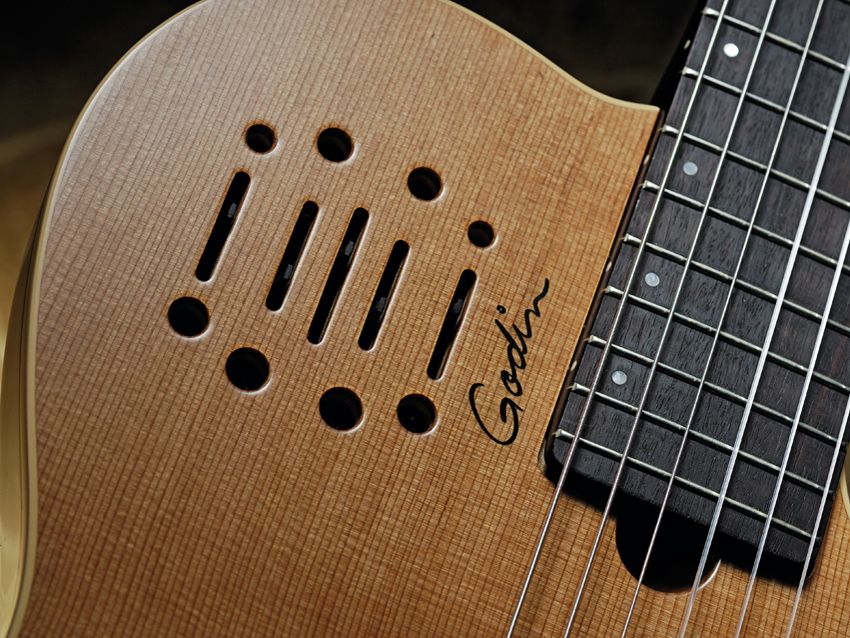 Tiny soundholes surround the controls for the guitar's electronics.