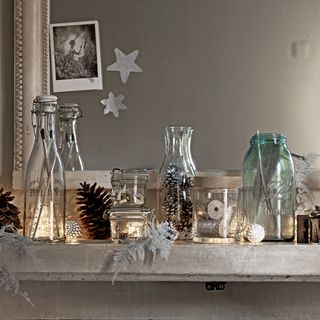 Display of vintage jars filled with decoration on a mantle piece