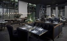 Restaurant with black furnishings, dark wood and bronze details