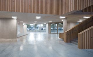Building that uses untreated wood, concrete, raw brickwork and large windows to create an open plan and contemporary.
