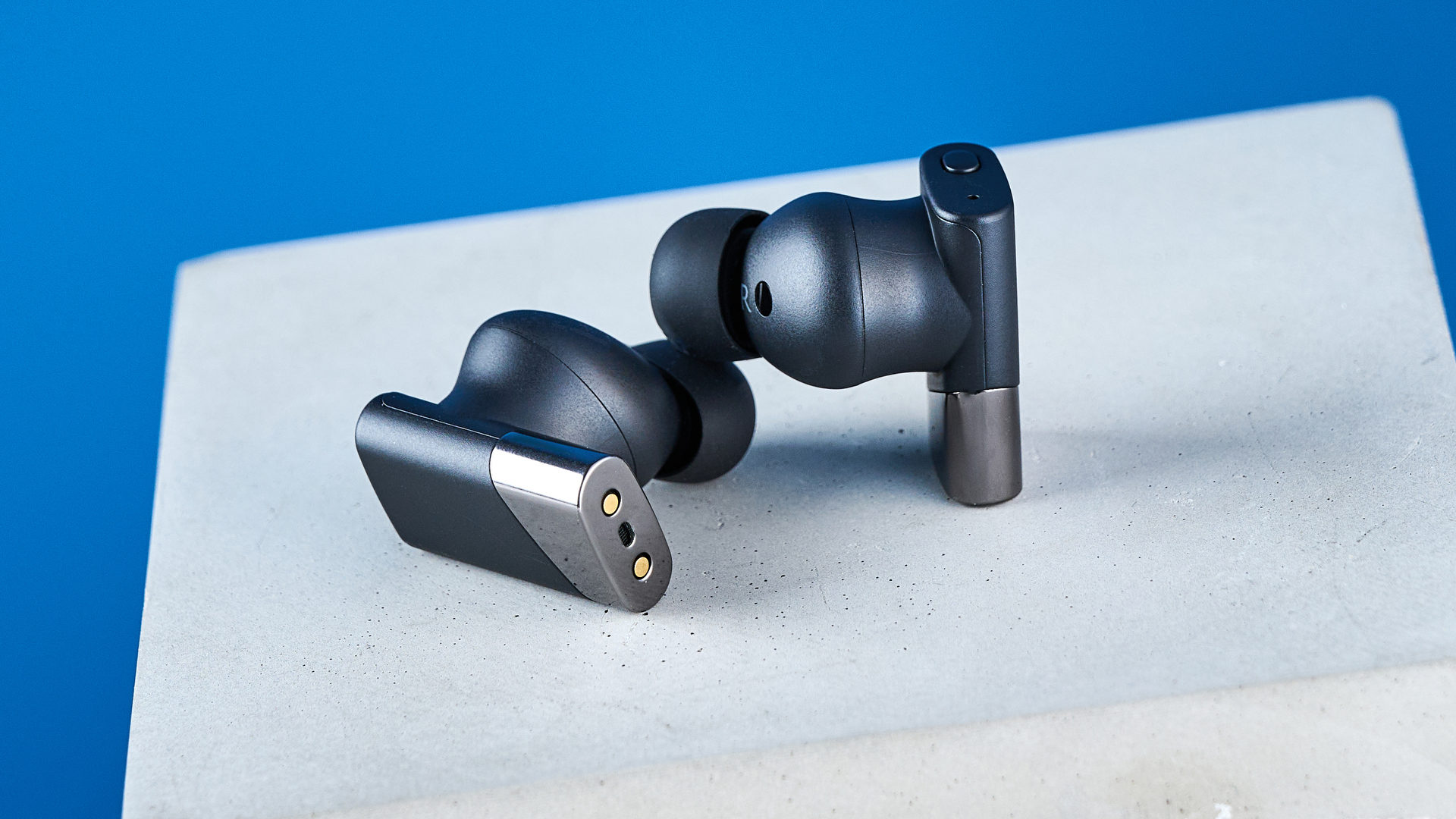 A pair of black Status Pro X wireless earbuds