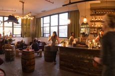 People relaxing in a bar with big windows in the early evening