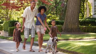 Happy family out walking their dog