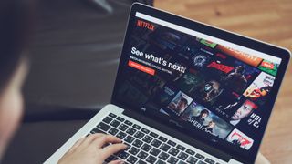 En kvinne som bruker Netflix på en laptop