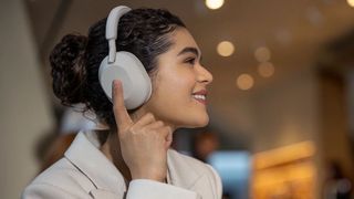 Woman wearing a pair of Sony WH-1000XM5 headphones
