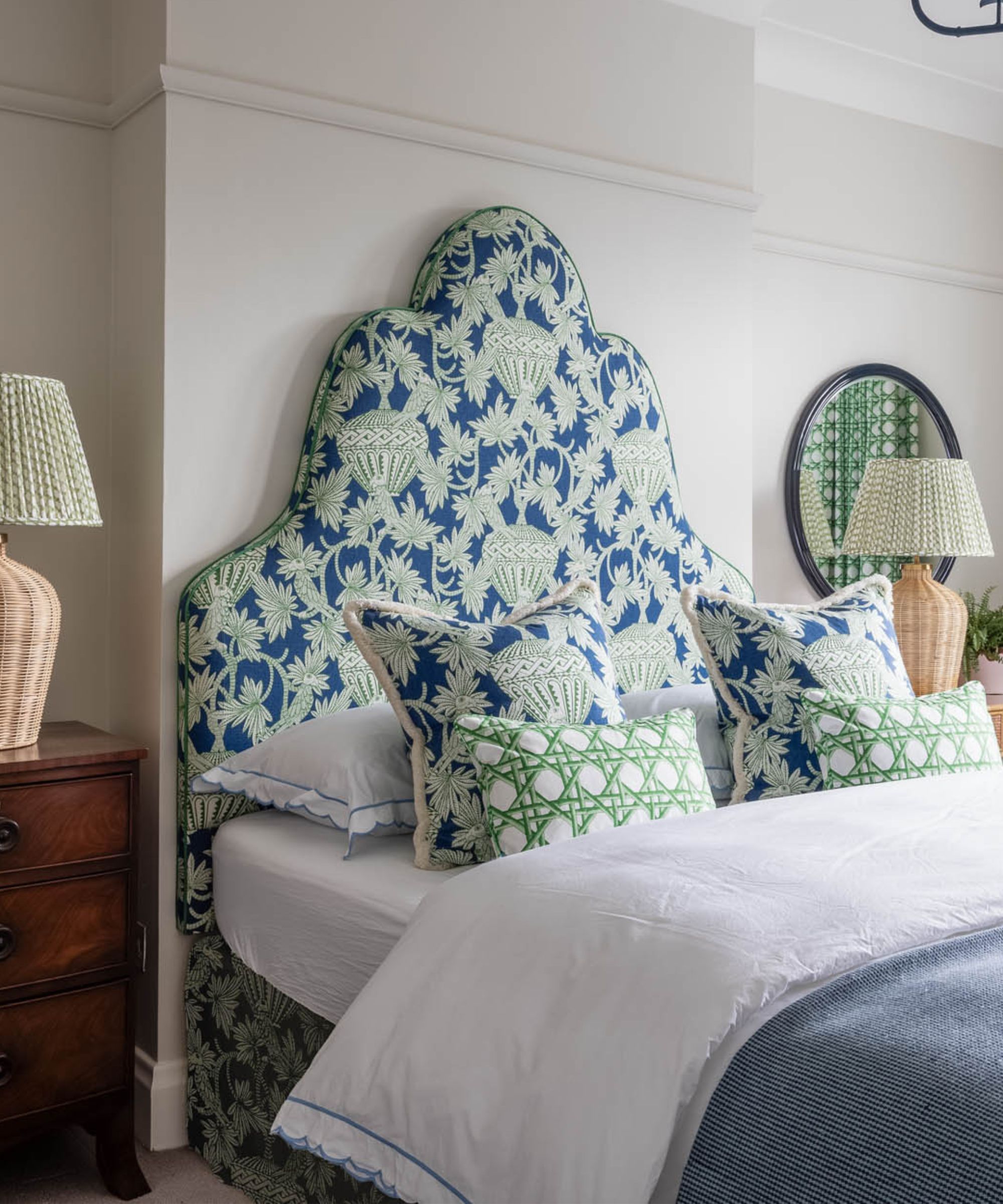 small bedroom with green and blue headboard