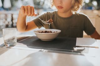 Child eating bowl of ultra processed cereal