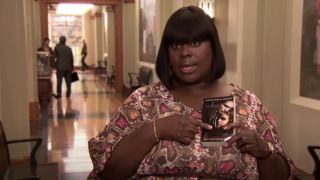 Retta as Donna, holding a copy of Twilight