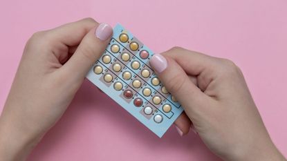 Contraceptive pill side effects: A woman holding a pill packet