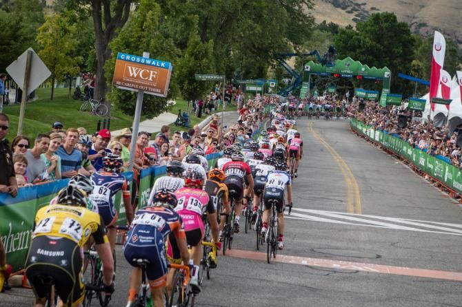 The peloton gets strung out as it heads through the finish for another lap.