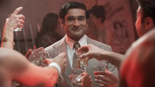 Somen &quot;Steve&quot; Banerjee (Kumail Nanjiani) smiling at the center of a toast in Welcome to Chippendales