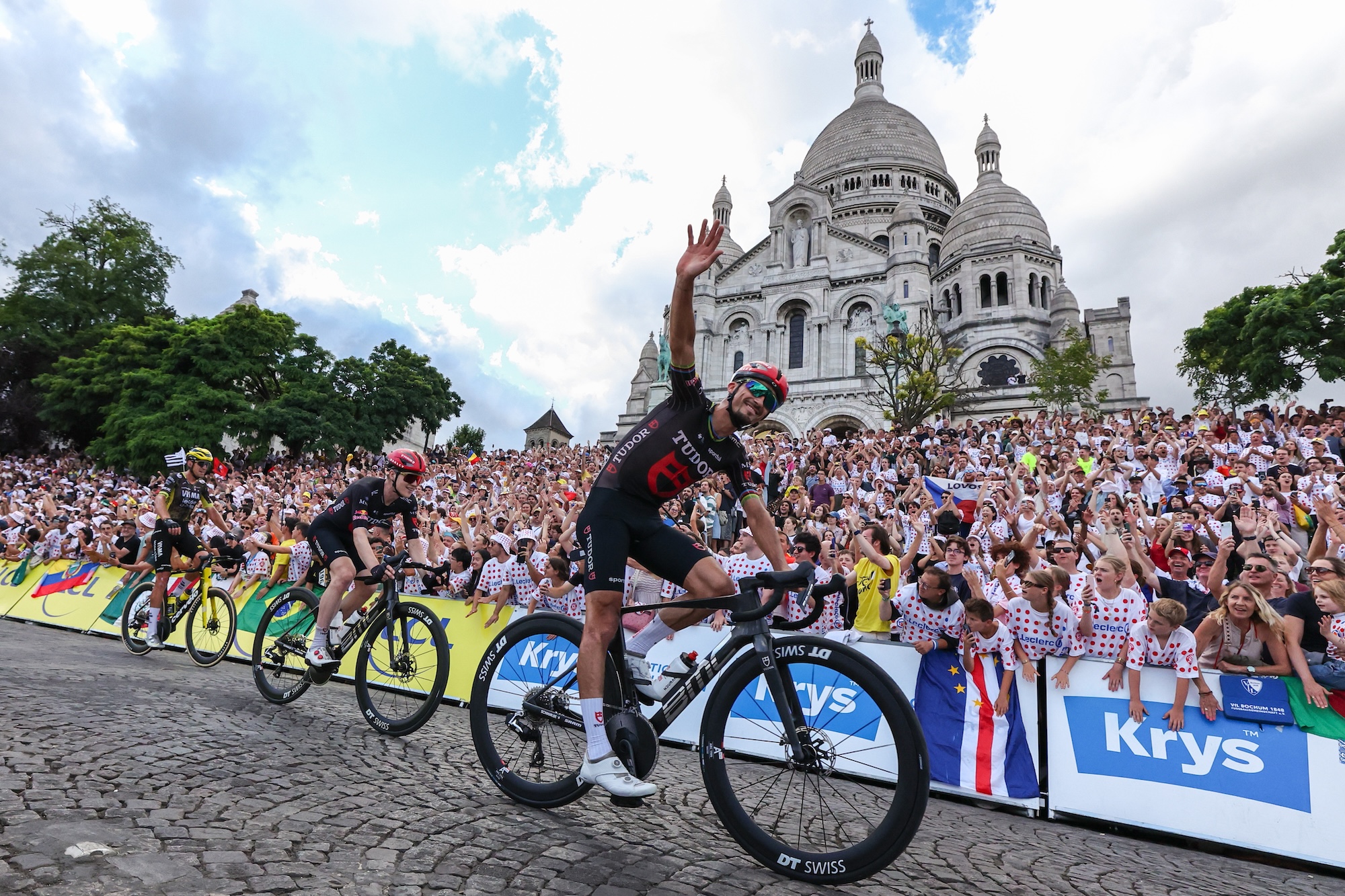 Julian Alaphilippe (Tudor Pro Cycling) waves to fans as he passes the Basilique du Sacre-Coeur on stage 21 of this year's Tour de France