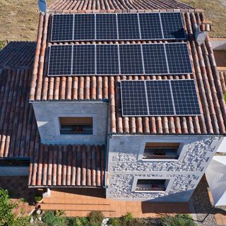 Overhead shot of house with brown roof with solar panels fitted