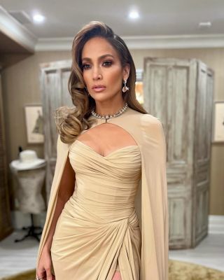 a close up of Jennifer Lopez in a draped corset gown with diamond earrings