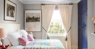 Grey bedroom with cream curtains to show how to get rid of dust by cleaning window treatments