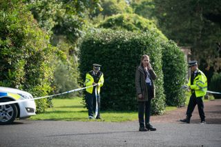 Gemma Whelan on the phone as police officers put up police tape around her.