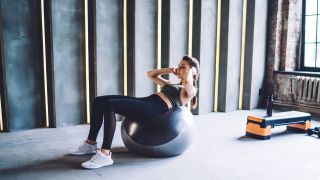 Woman performs the Swiss ball crunch