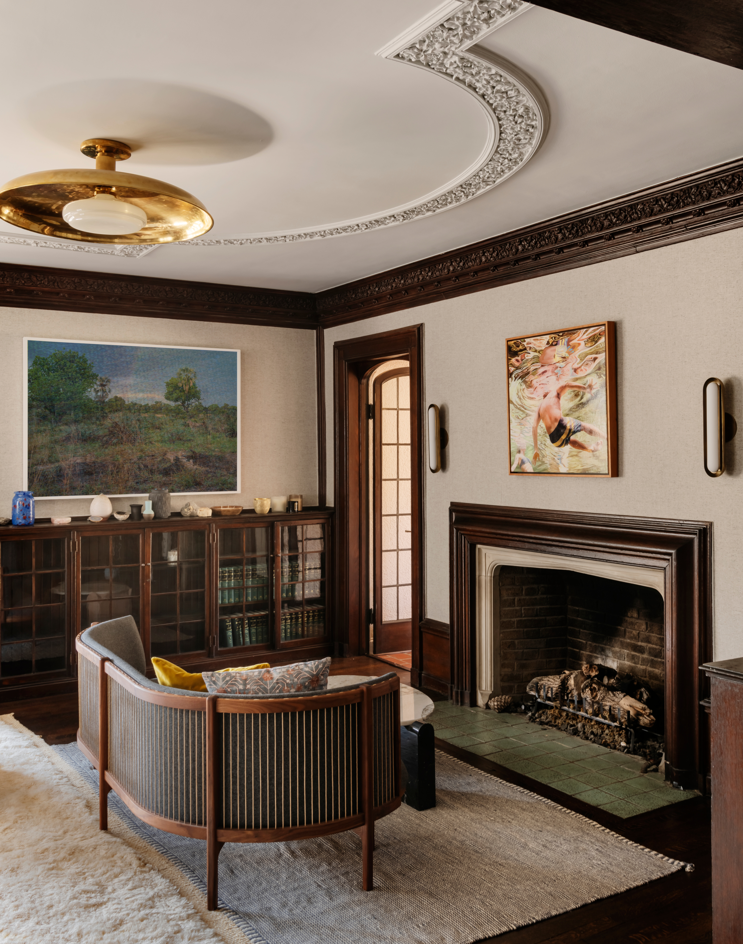 Snug area with fireplace, glass-fronted sideboard and curved daybed