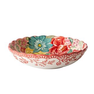 A floral pasta bowl with scalloped edges and red and blue painted flowers within it