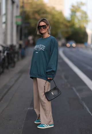 woman wearing crewneck, khaki pants, and adidas sambas