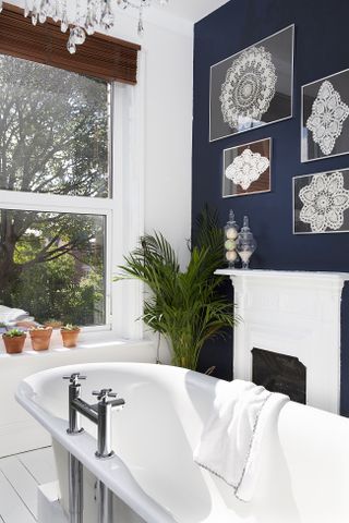 bathroom with dark blue walls and decorative lace gallery wall