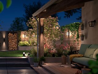 wall lights in a modern garden with an outdoor sofa, decking and panelled fences
