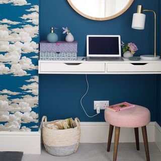 Blue home office area with white desk and clouds wallpaper