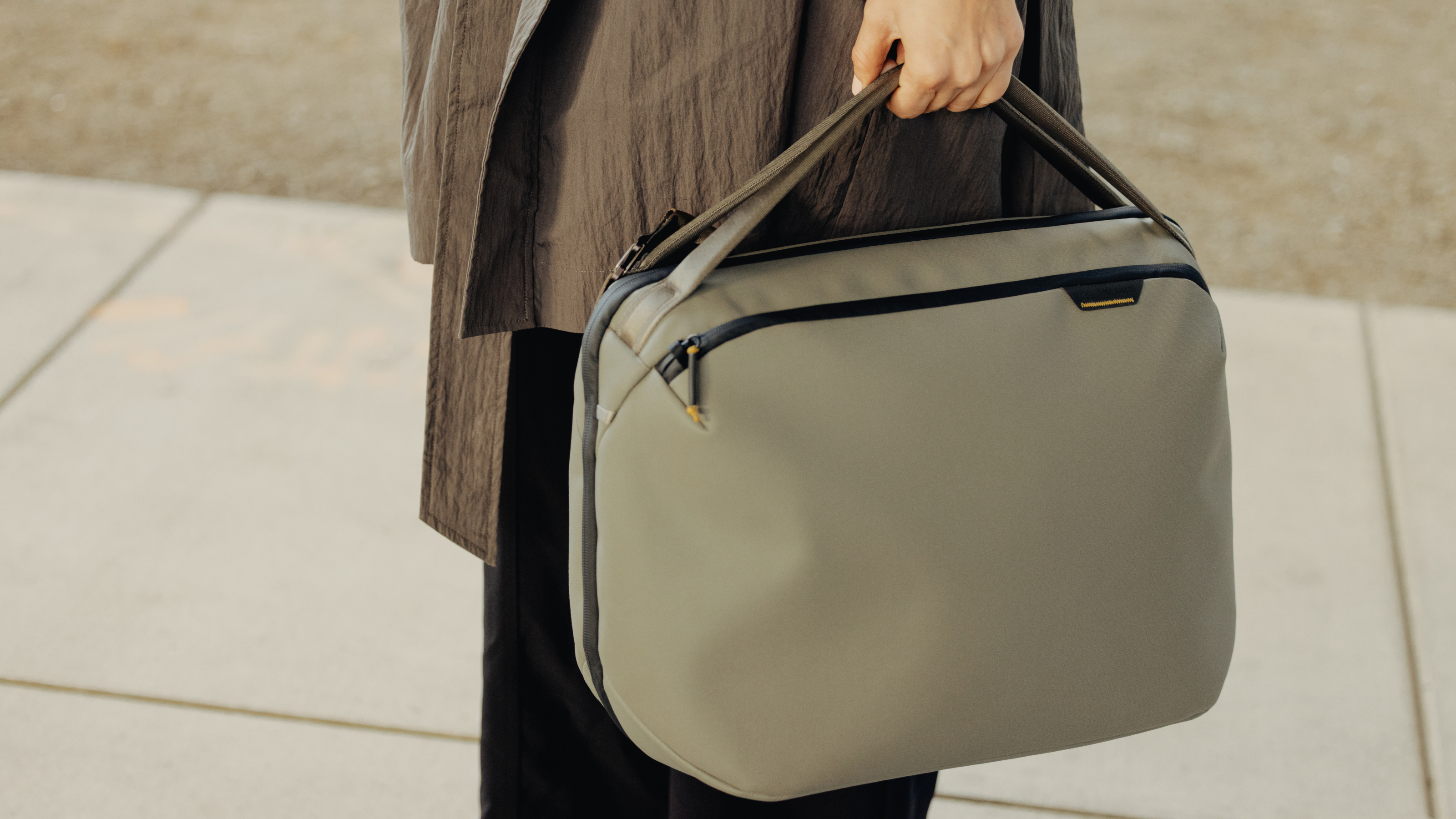 Hand holding Peak Design Travel Weekender 25L, a duffel-style bag