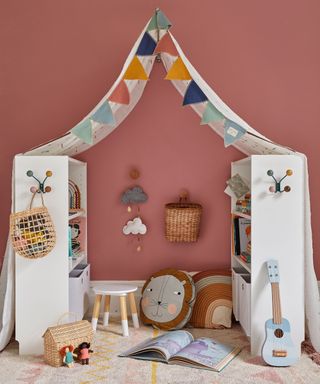 girls bedroom with red wall, bookcases, bunting and canopy