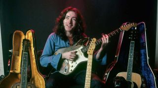 Rory Gallagher playing his Stratocaster, surrounded by other instruments