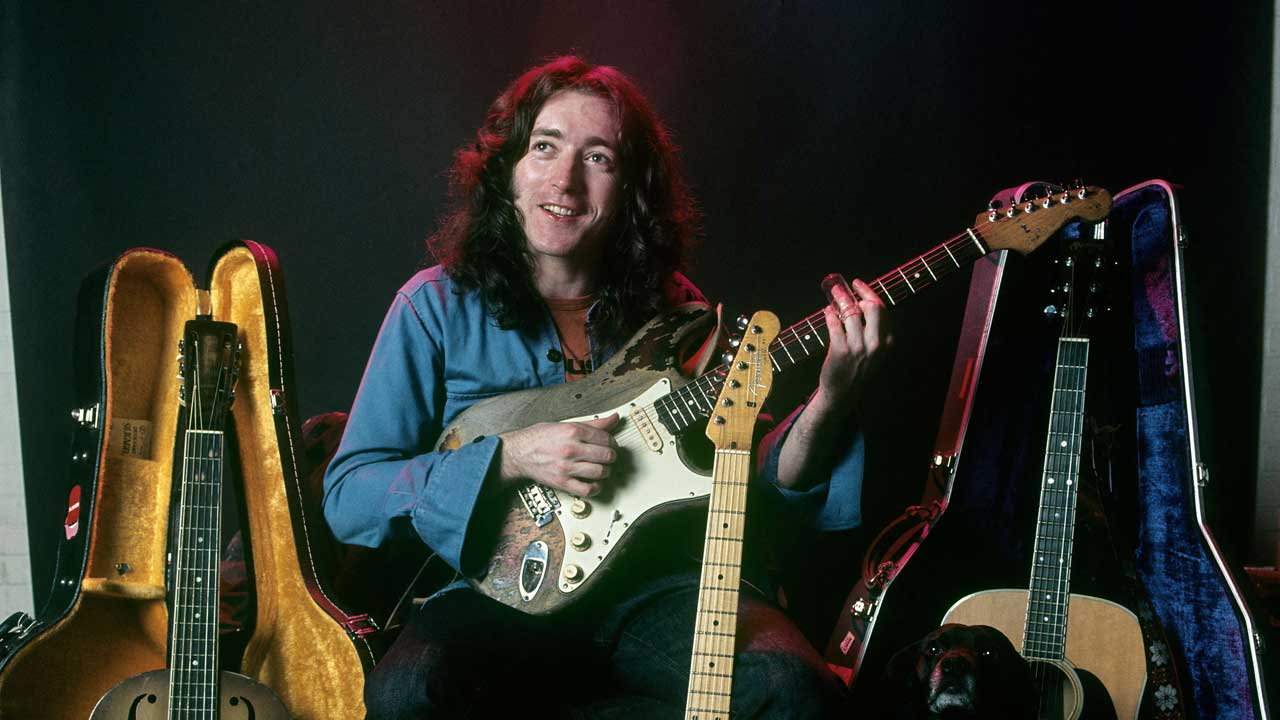 Rory Gallagher playing his Stratocaster, surrounded by other instruments