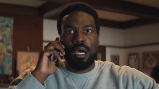 Wonder Man holds a phone to his head open-mouthed