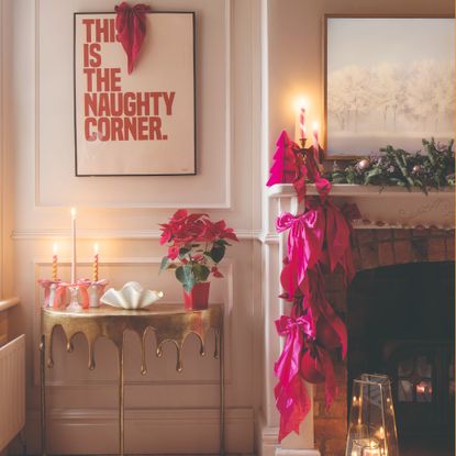 A living room decorated for Christmas with pink satin bows adorning the fireplace