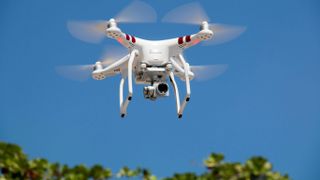 A drone flying against a blue sky 