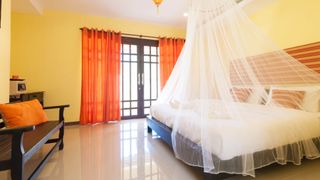 A bedroom with a mosquito net over the bed