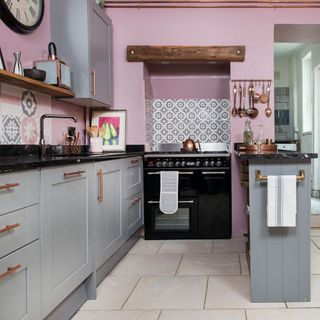 kitchen with pink wall grey counter and black dishwasher