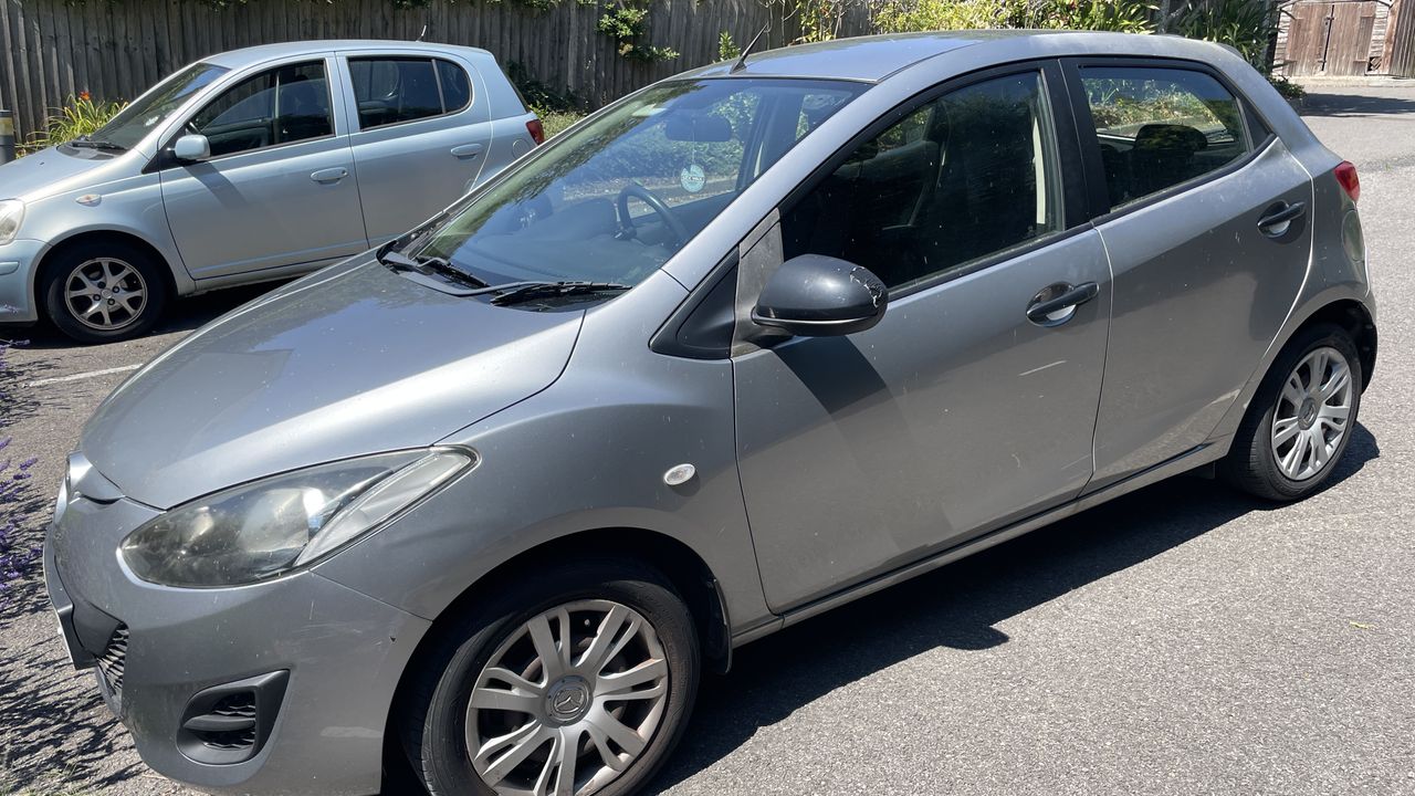 A car parked on a driveway, on a hot day