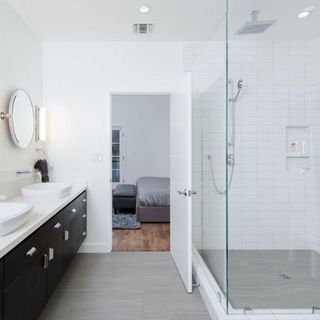 bathroom with shower area and sinks