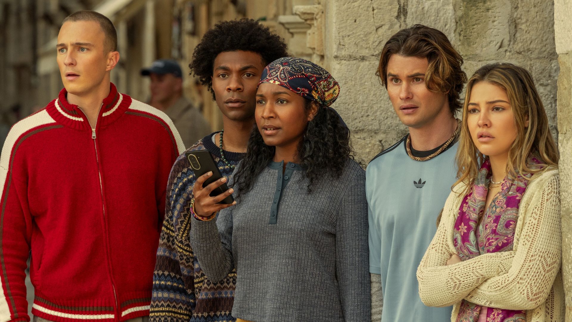 A group of teens look at something offscreen