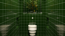 Green tiles placed all over a bathroom with a toilet fixed in the middle.