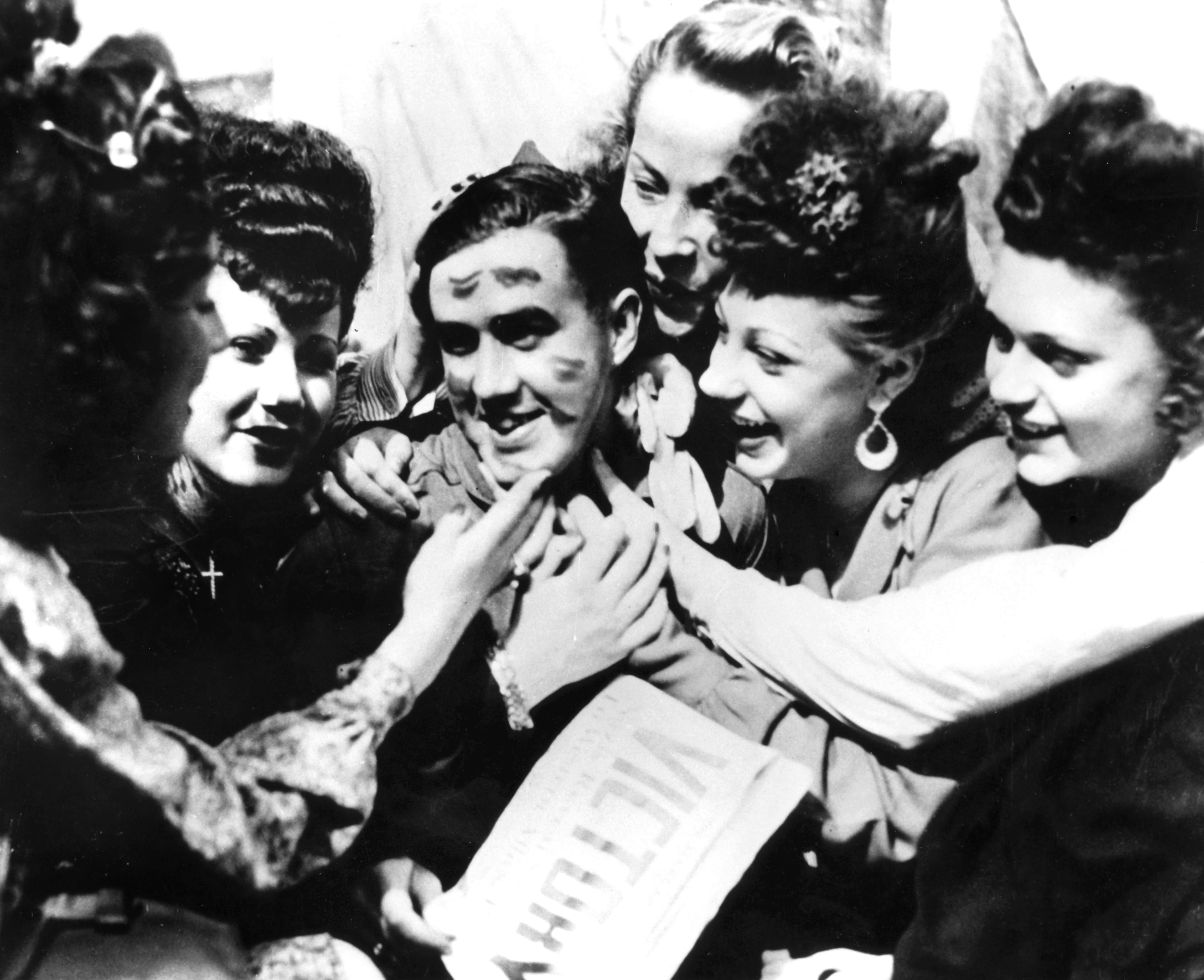 VE Day celebrations, Paris, 8 May 1945. A soldier smothere with kisses by jubilant women