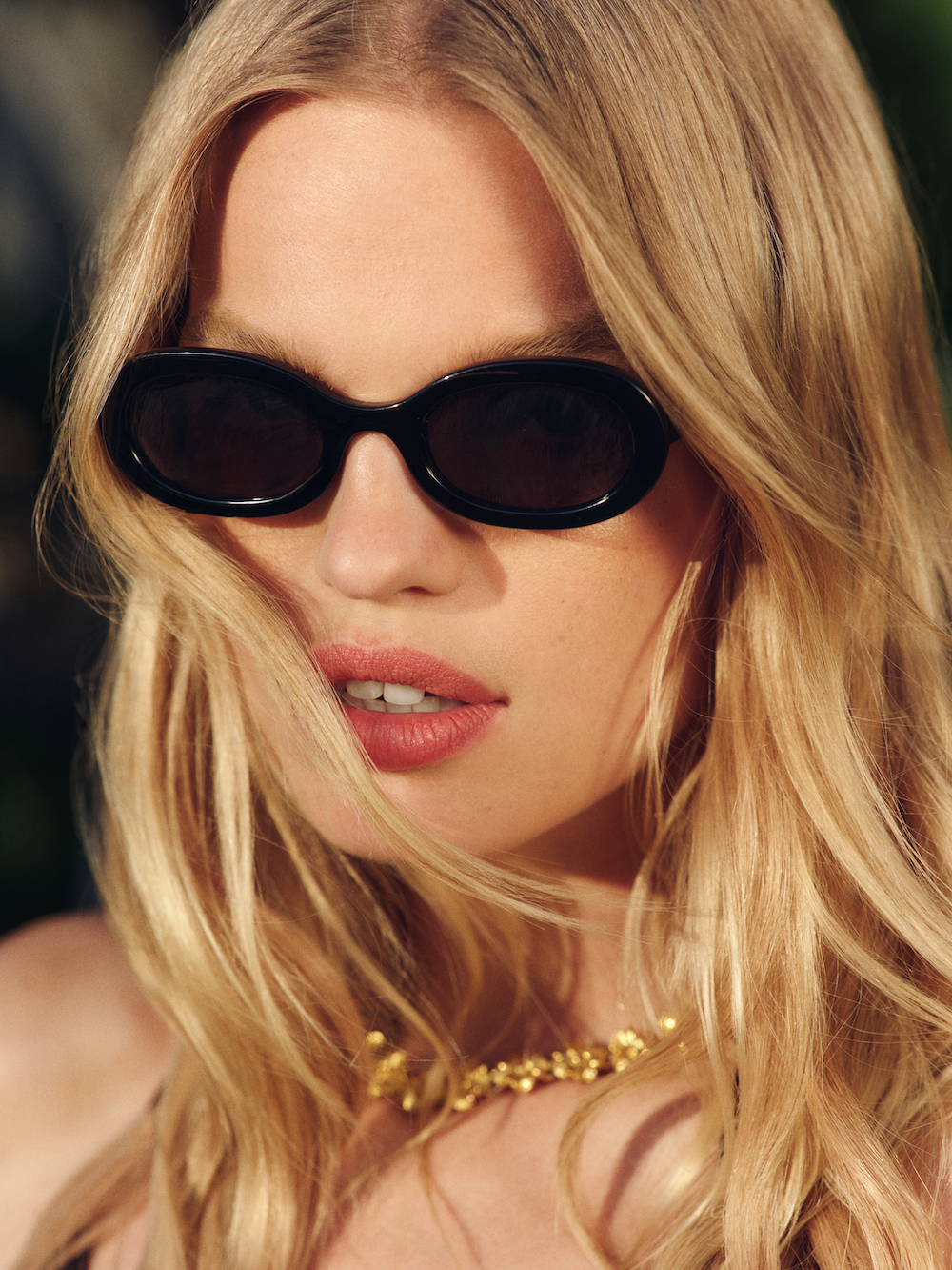 a close up of a model wearing a pair of reformation sunglasses