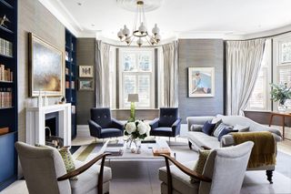 Grey living room with navy blue armchairs and alcove bookcases