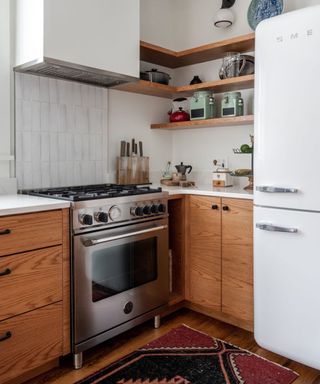 wooden kitchen cabinets with white walls and tiles with a vintage rug