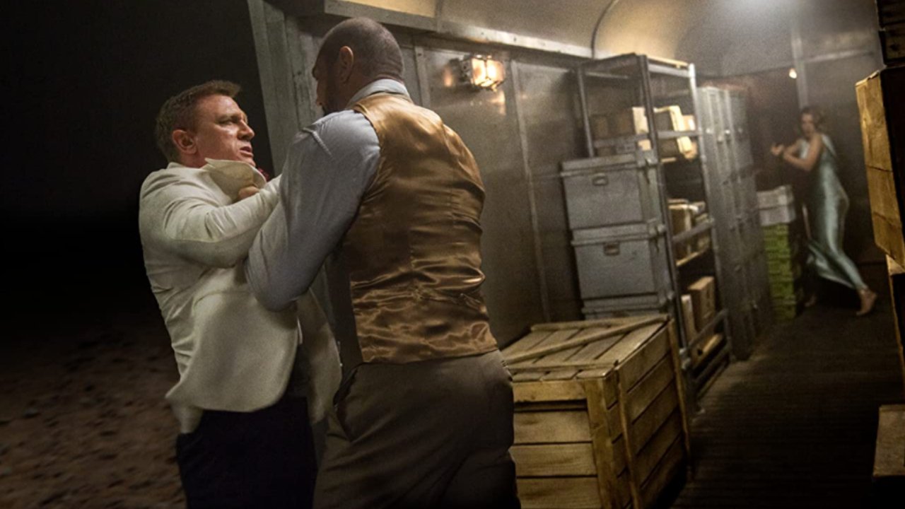 Daniel Craig fighting Dave Bautista as Léa Seydoux takes aim in Spectre.