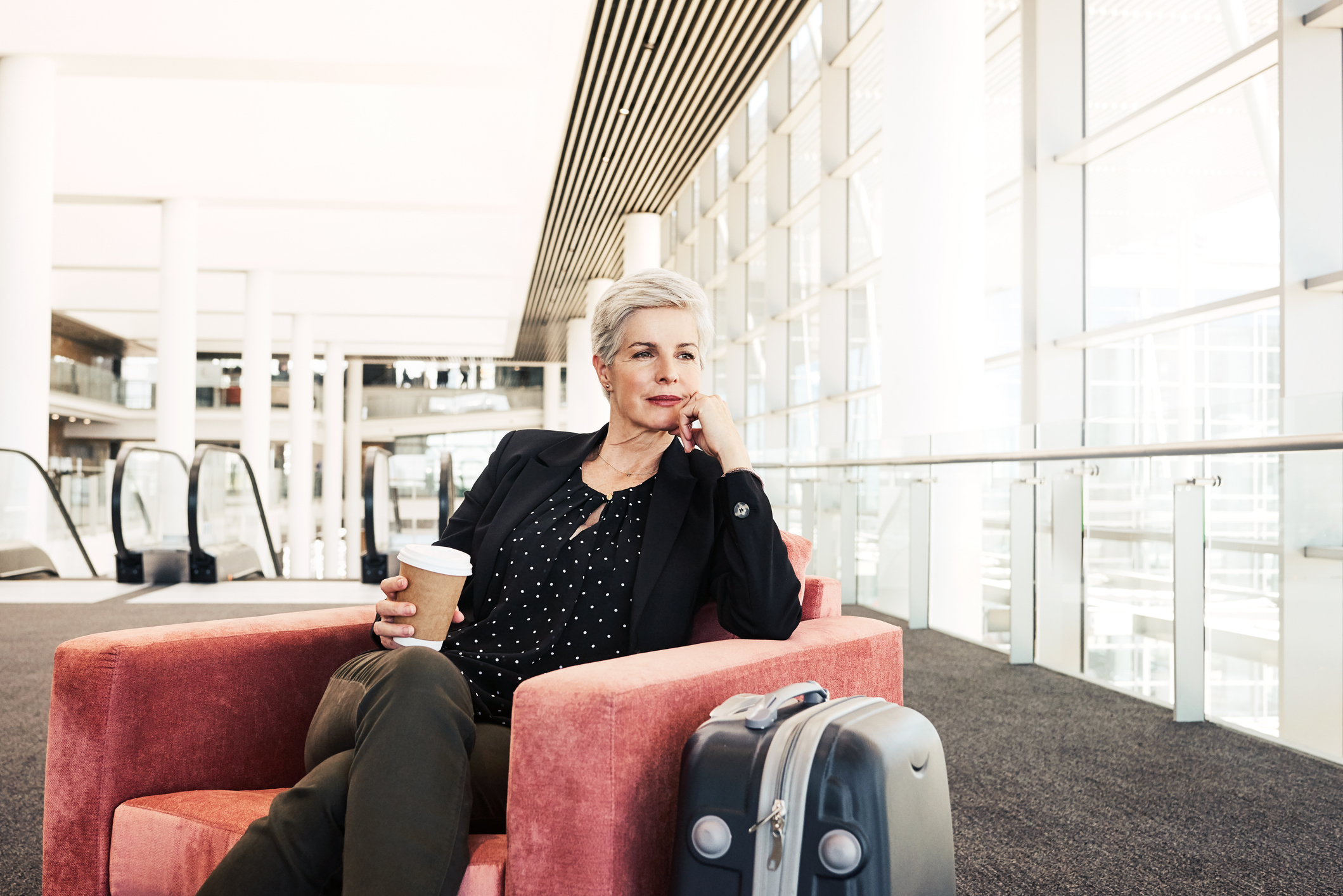 Shot of a businesswoman sitting on a chair in an airport lounge