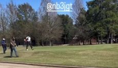 Tiger Woods walks down the fairway with a golf bag on his back