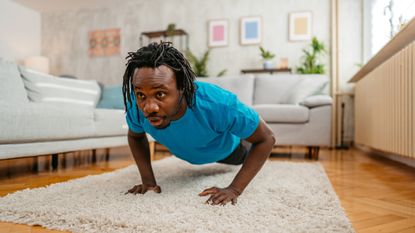 Man performing push-up in his living room