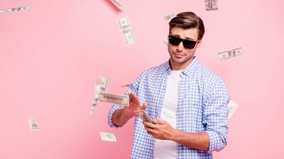 A young man throws money around while looking a bit smug.