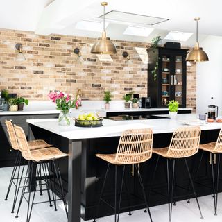 kitchen island with black units, white top and rattan stools